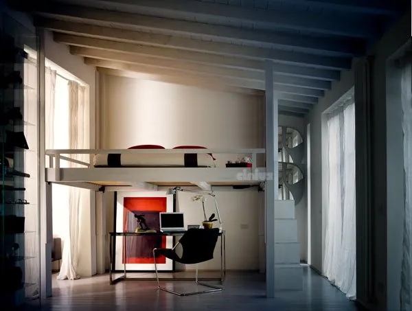 Rising loft bed lowered above a home study