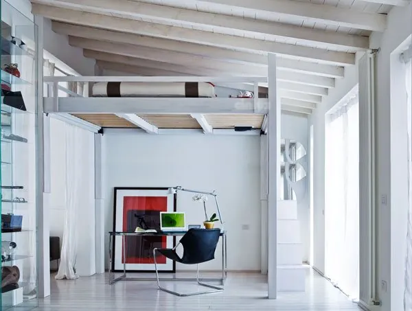 Rising loft bed raised above a home study under exposed beams